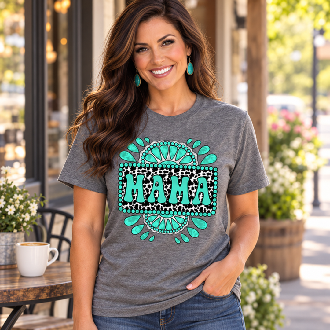 Woman wearing a turquoise Mama graphic tee outside a small-town cafe