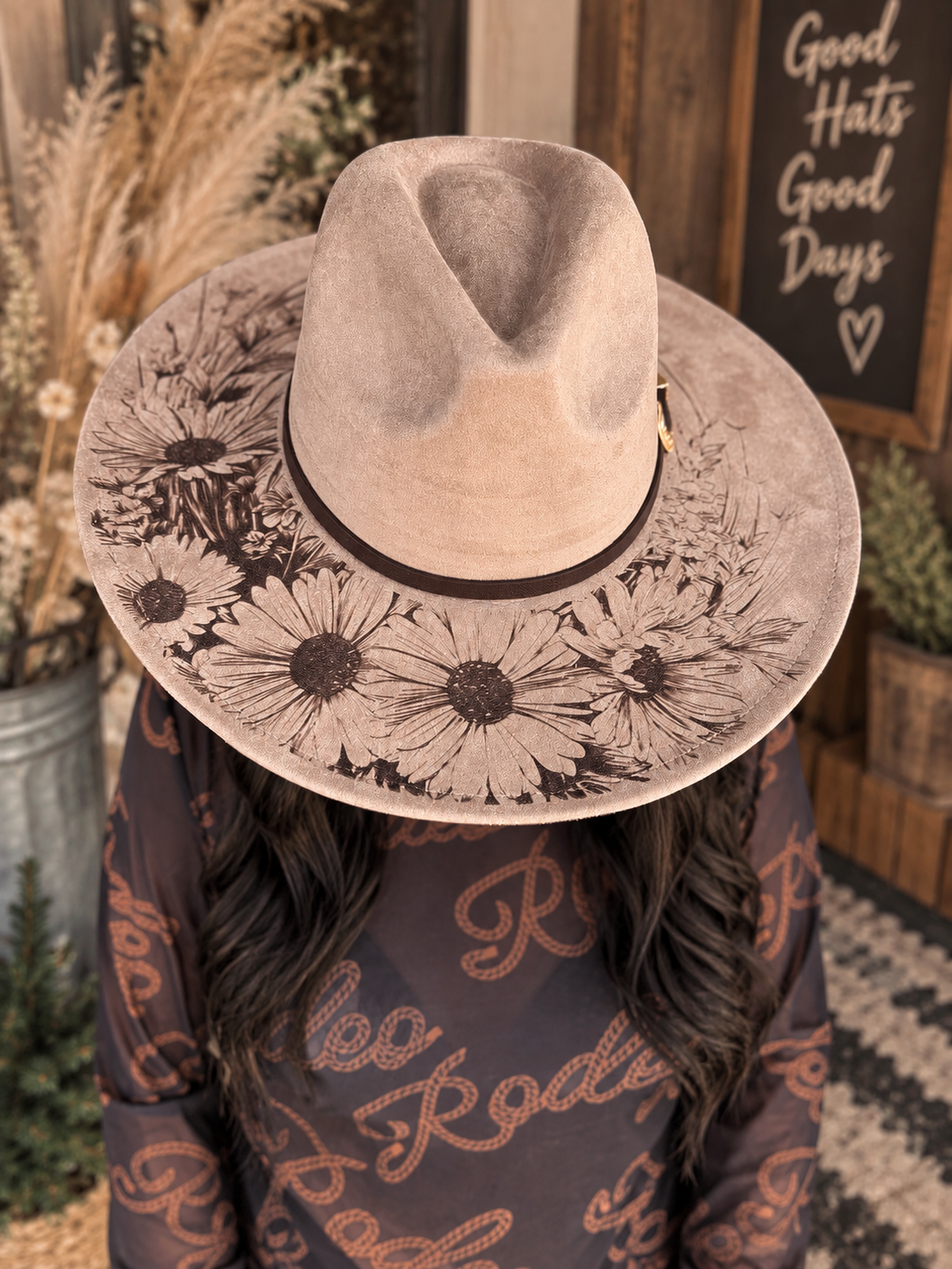 Woman wearing the taupe Wild Daisy Western hat with floral brim design and dark band