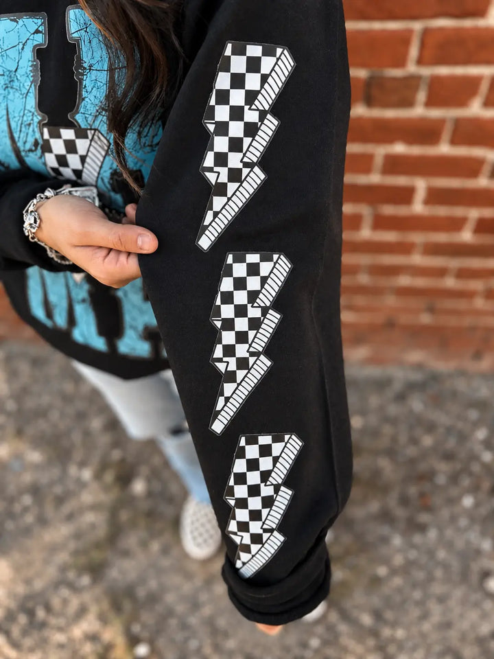 Close-up of checkered lightning bolt sleeve graphics on Black Mama crewneck