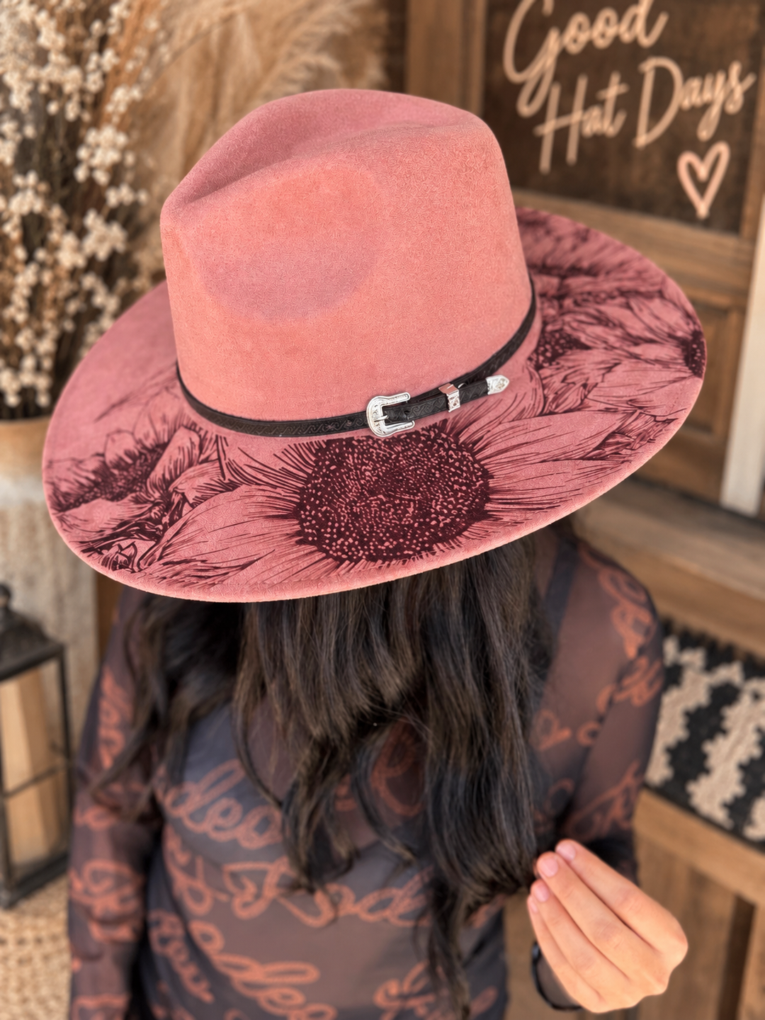 Front view of a woman wearing the pink Sunset Bloom Western hat with sunflower design