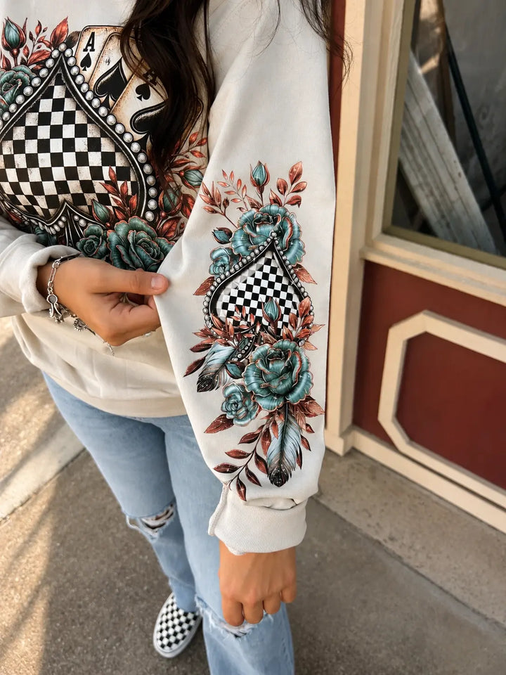Close-up of floral checkered spade sleeve artwork on Sand crewneck sweatshirt