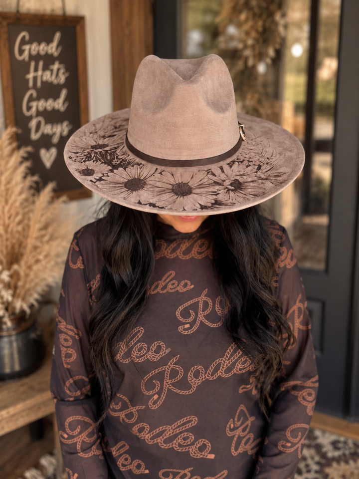 Angled front view of a woman wearing the Wild Daisy Western hat with daisy artwork
