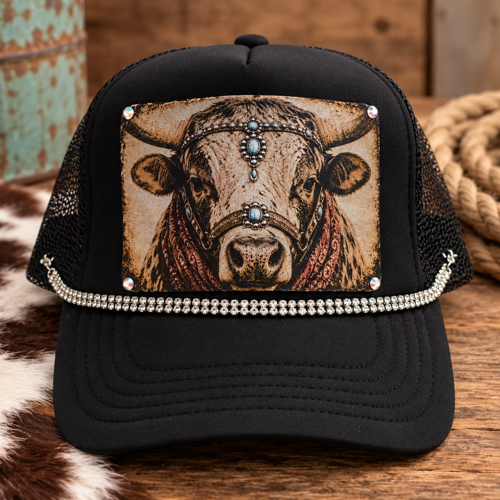 Rhinestone Ranch Cow Trucker Hat in black with vintage cow portrait patch, turquoise accents, rust bandana details, and rhinestone trim