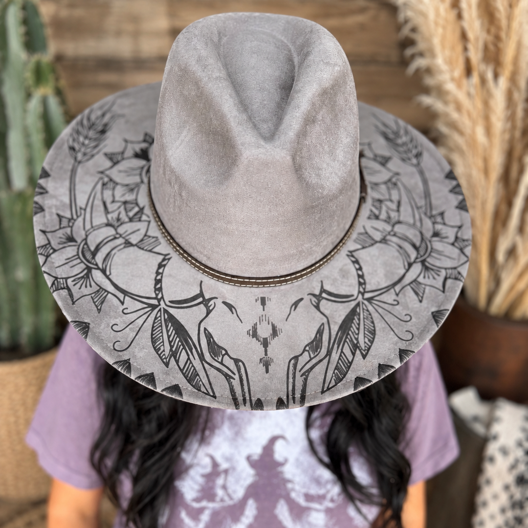 Front view of the Wildflower Outlaw hat showing longhorn skull, floral, and feather brim artwork