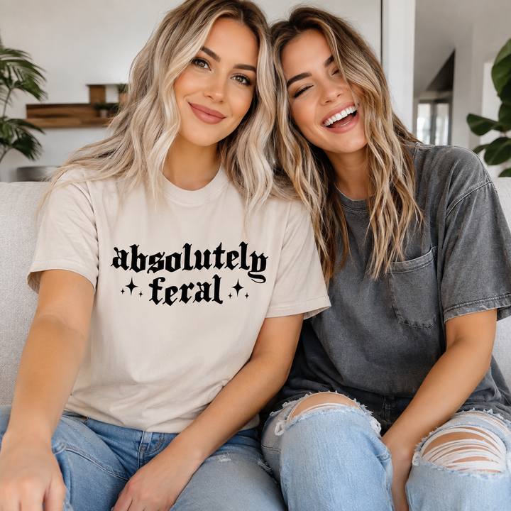 Blonde woman wearing the Absolutely Feral sand funny graphic tee with a friend