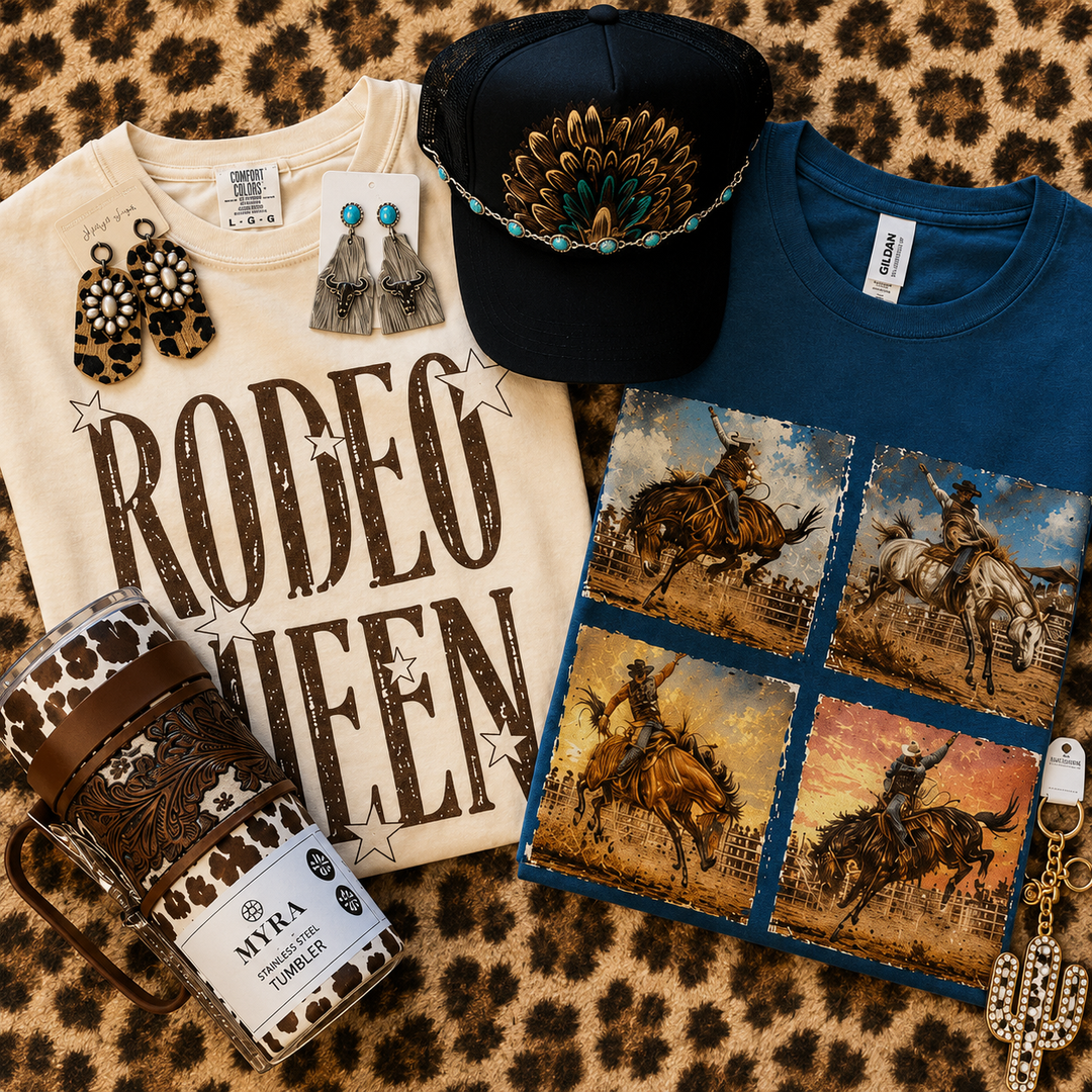 Close flat lay of representative August Wild Soul Deluxe Box tees, hat, tumbler, and accessories; contents vary