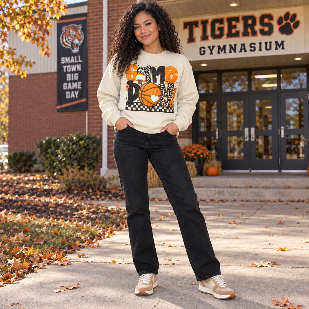 Game Day Basketball sand crewneck sweatshirt on curly-haired model outside gym