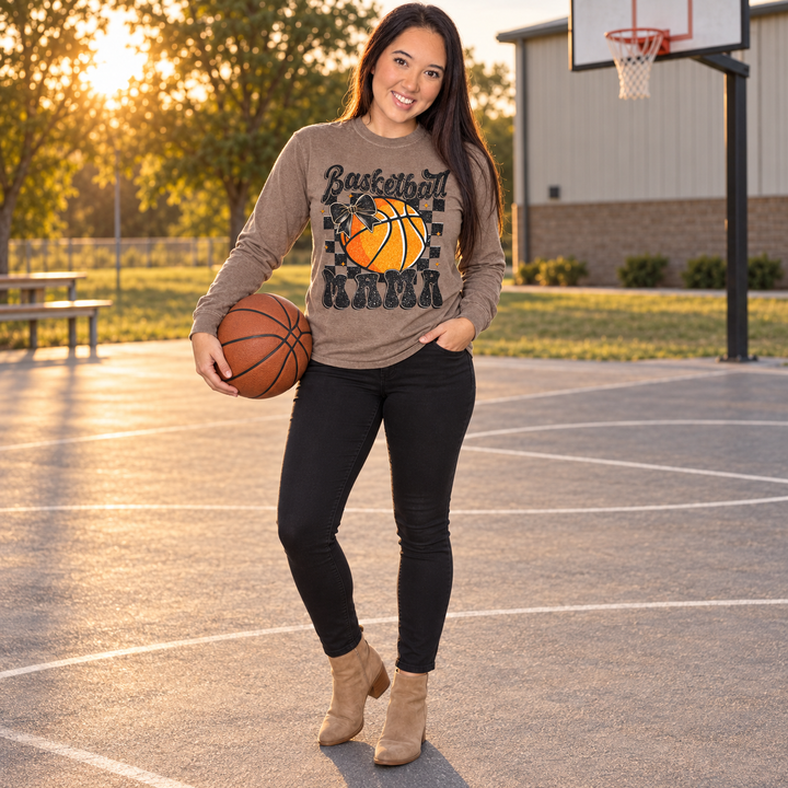 Woman wearing Basketball Mama espresso long-sleeve tee on a small-town outdoor court