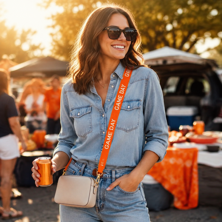Woman wearing an orange Game Day beaded crossbody purse strap at a tailgate