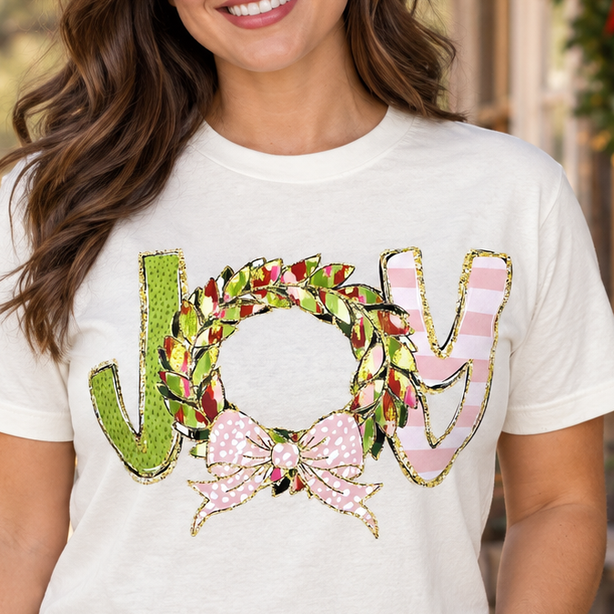 Brunette wearing the ivory Christmas JOY wreath graphic tee in a close Texas portrait