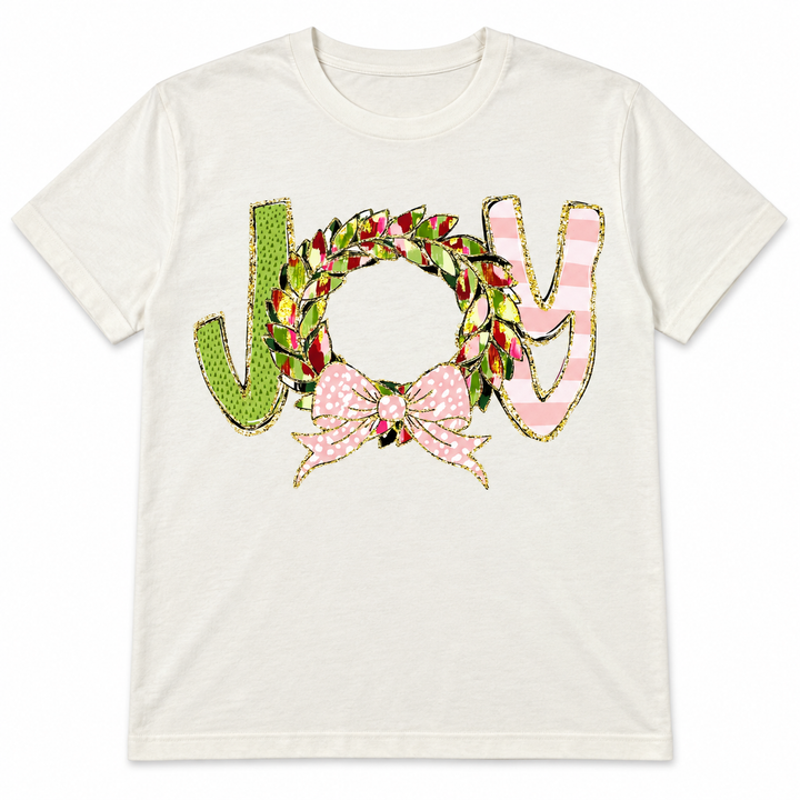 Ivory Christmas JOY wreath and pink bow graphic T-shirt laid flat on pure white