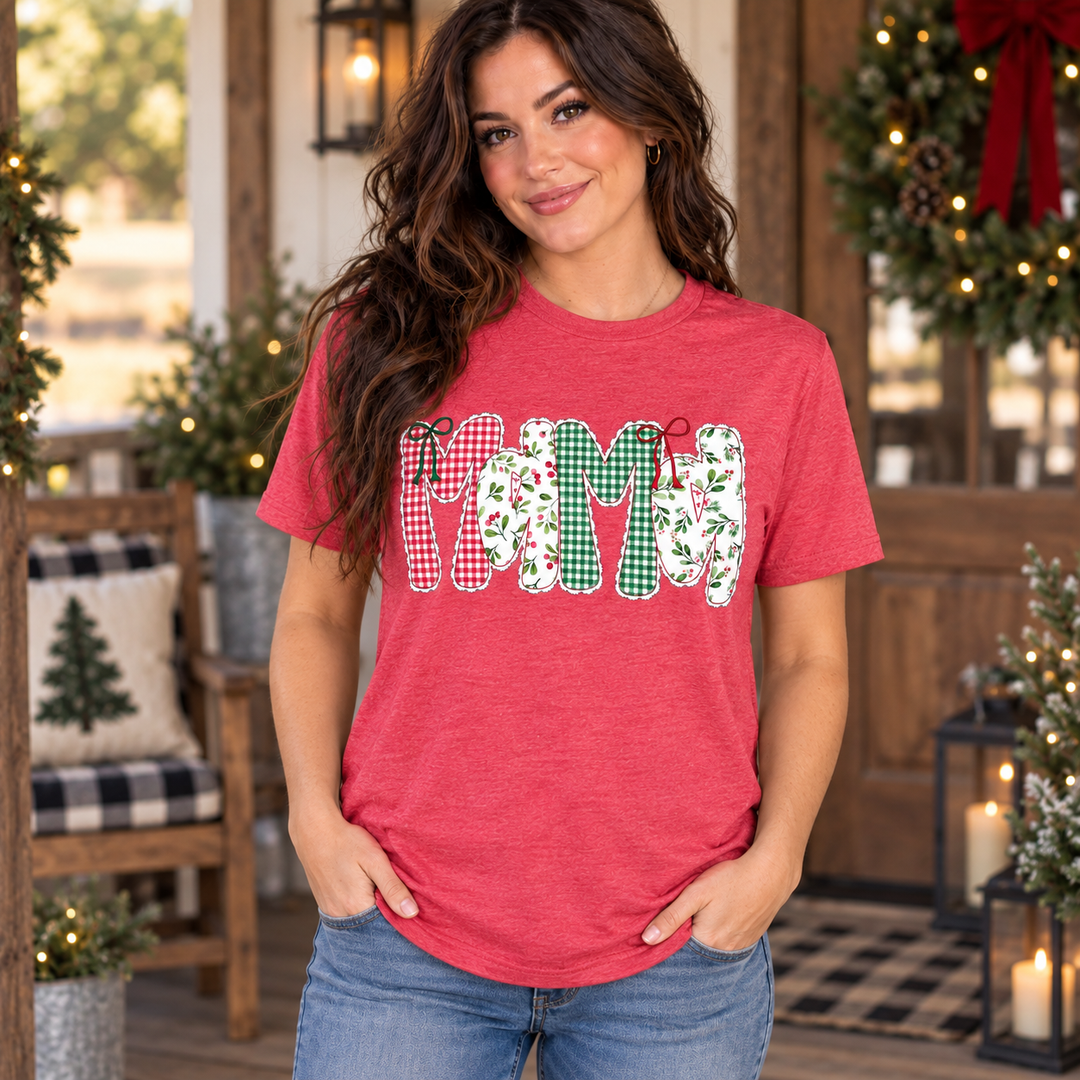 Brunette wearing the heather red Christmas Mama mistletoe graphic tee in a close Western holiday portrait