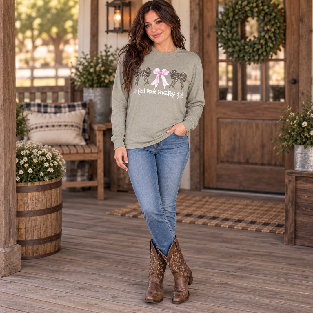 Full-body brunette wearing the sage So God Made Country Girls tee on a Western ranch porch