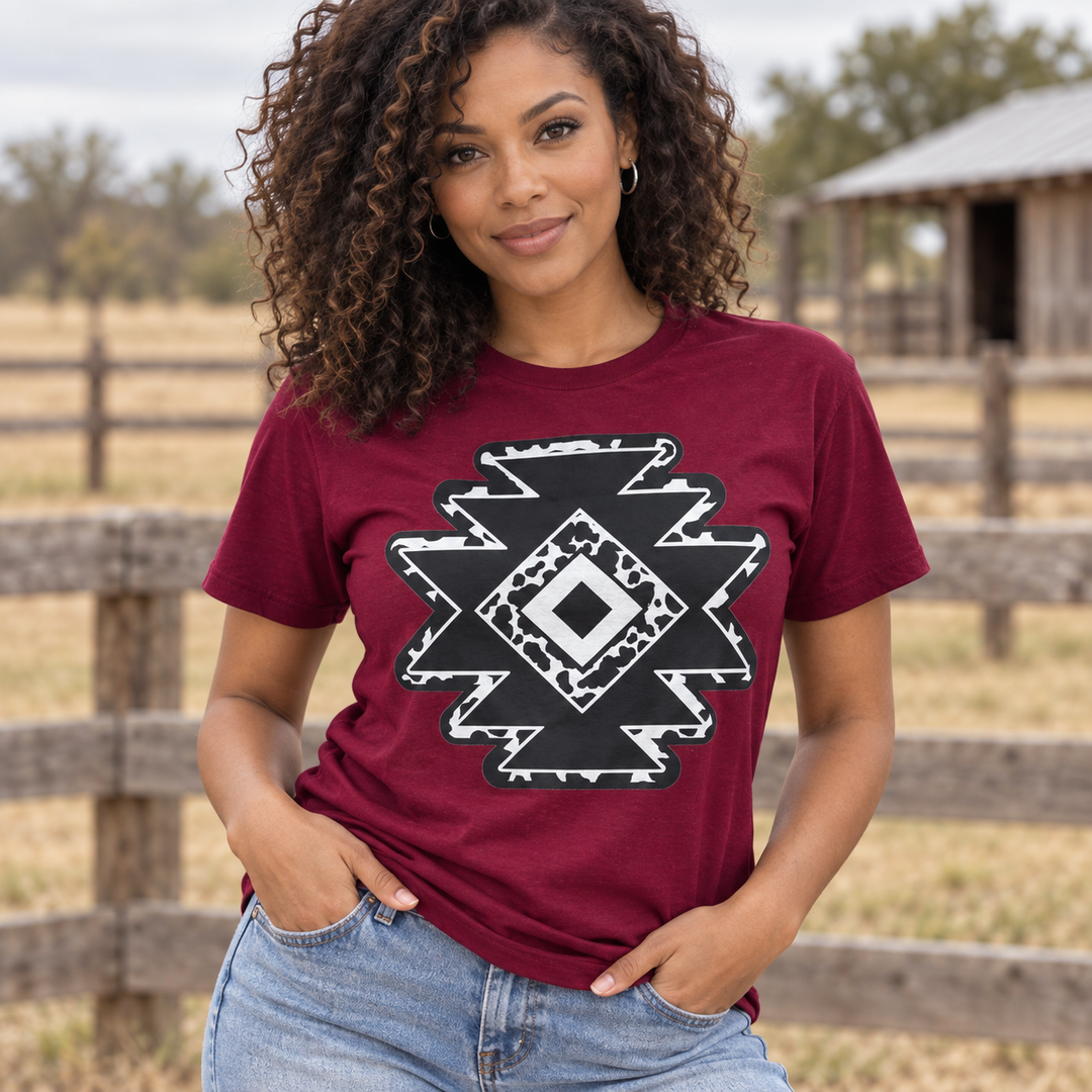 Cowprint Aztec Diamond burgundy tee close model view at a ranch fence