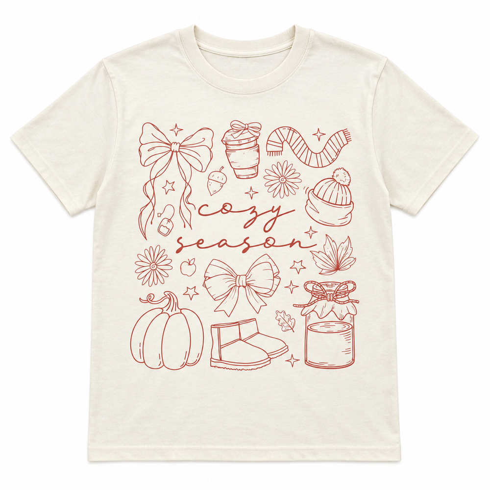 Cozy Season Essentials Natural Fall Graphic Tee laid flat on pure white