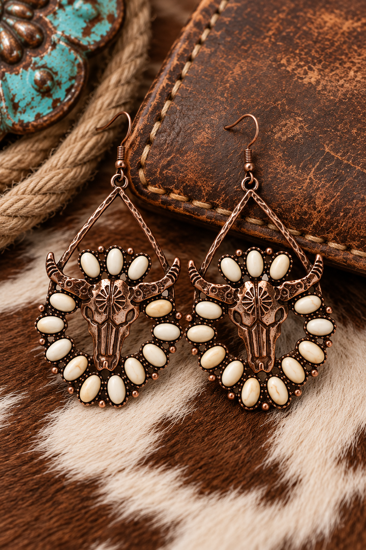 Desert Longhorn Earrings styled on cowhide beside weathered Western leather