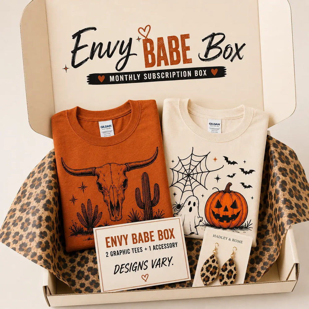 Envy Babe monthly subscription box with two representative graphic tees and one accessory; designs vary