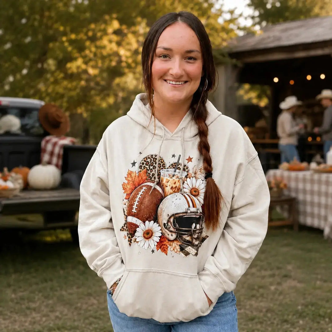 Brunette woman wearing the Game Day Coffee Sand hoodie at a fall tailgate