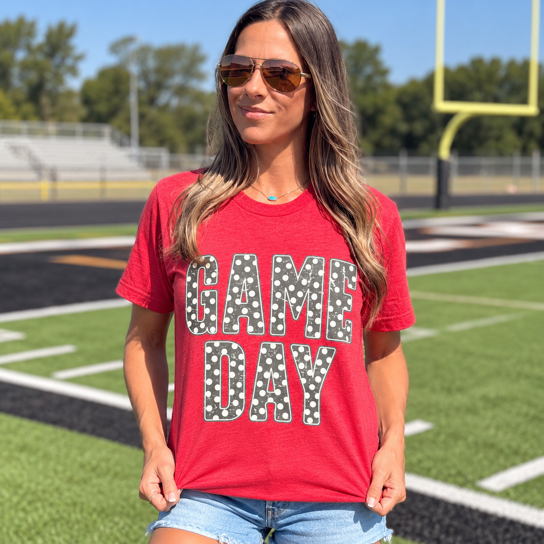 Game Day polka dot graphic tee close model view at a small-town football field
