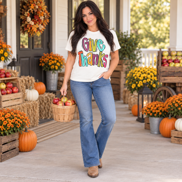Woman wearing Give Thanks natural graphic tee at a small-town harvest market