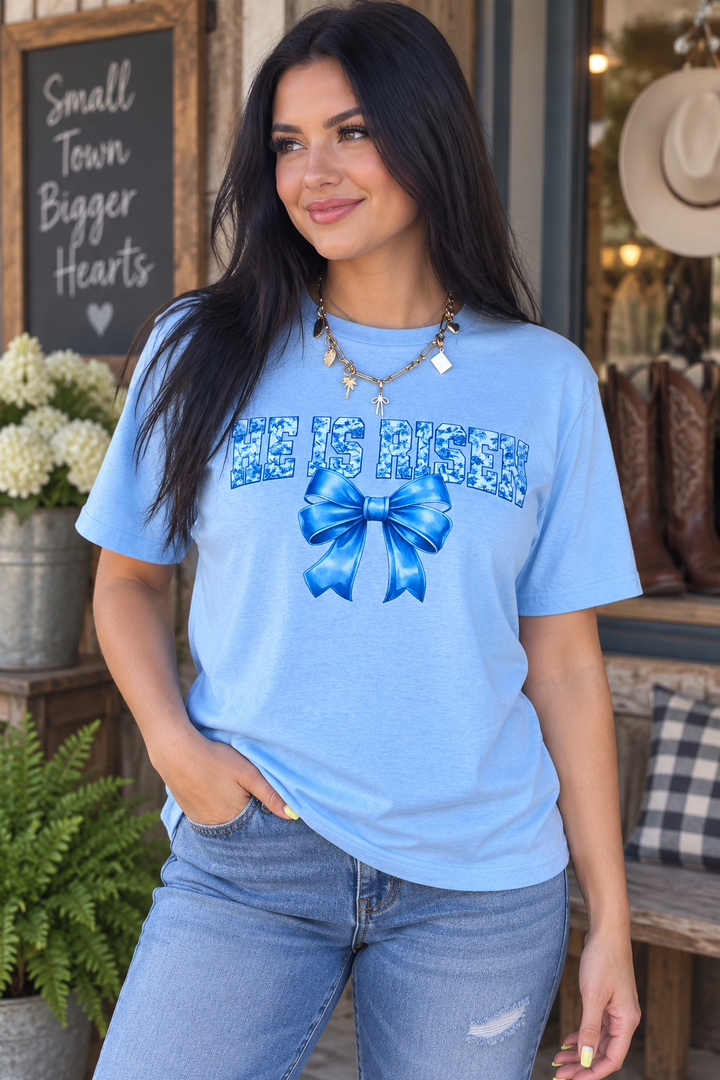 Woman wearing He Is Risen blue bow faith graphic tee