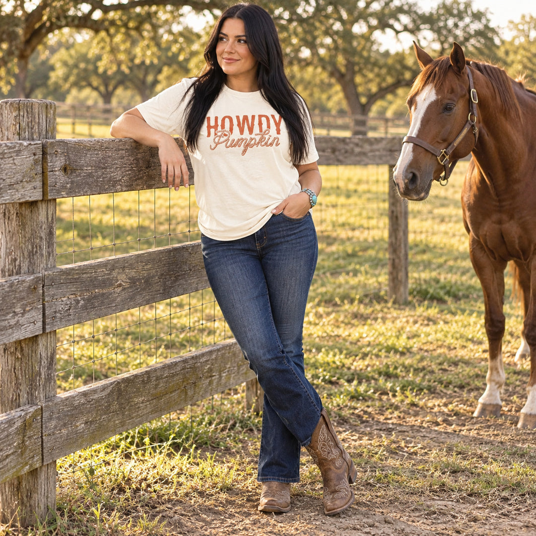 Woman wearing Howdy Pumpkin Rope Natural Western Fall Tee beside a horse on a Texas ranch