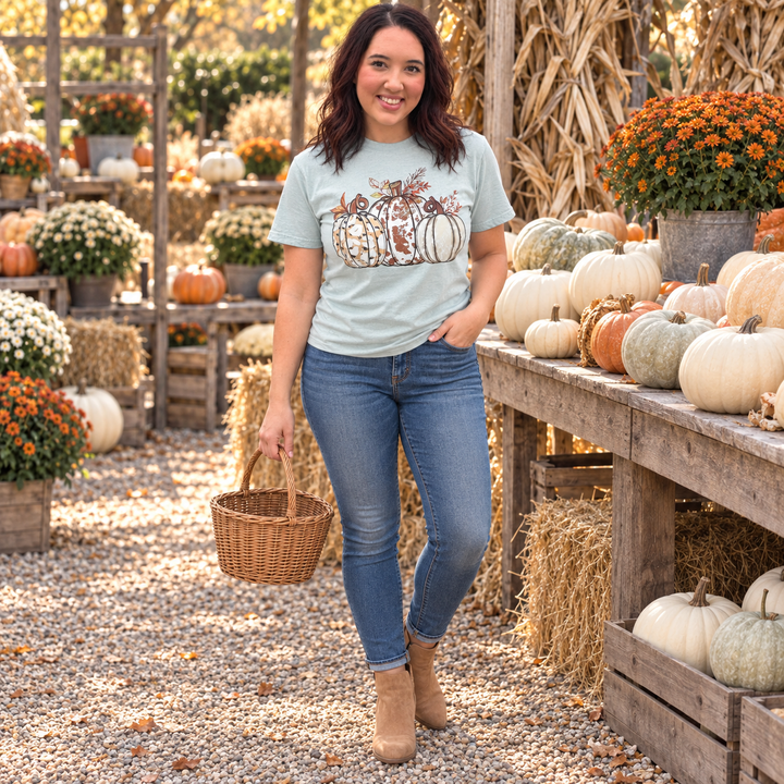 Woman wearing Ivory Pumpkins bay graphic tee at a fall farm stand