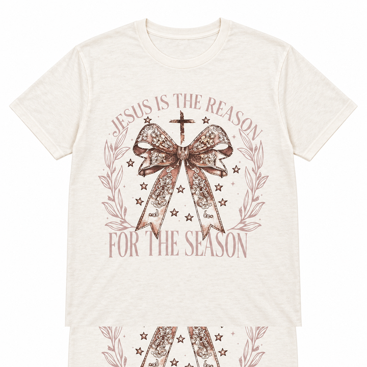Jesus Is the Reason bow and leaf light beige Christmas tee laid flat on pure white