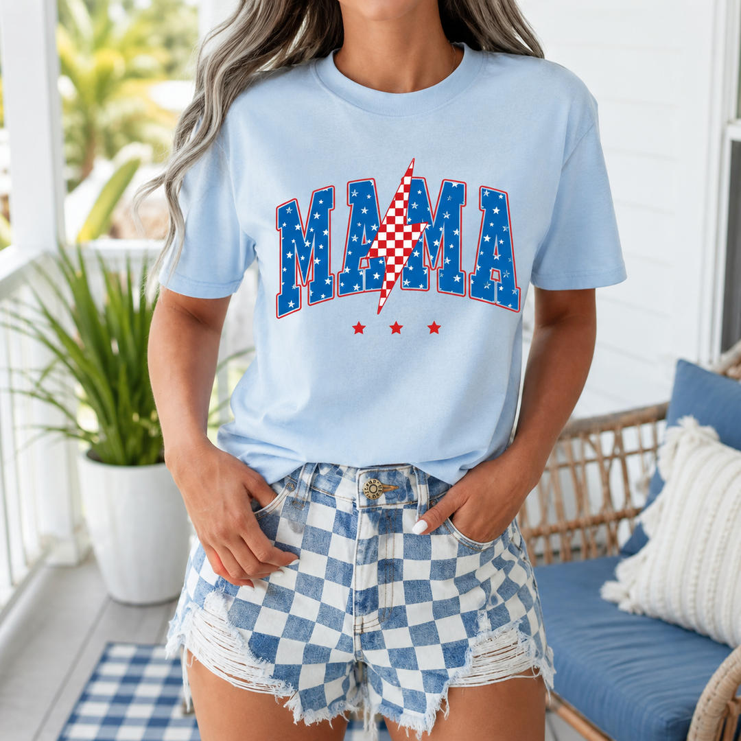 Woman wearing the pale-blue Mama Lightning Bolt patriotic graphic tee on a summer porch