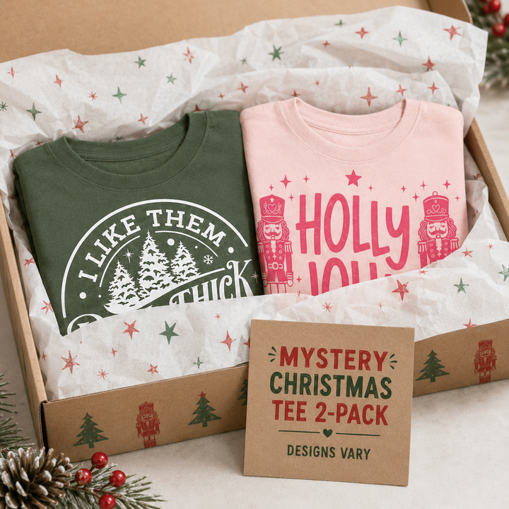 Mystery Tultex Christmas tee two-pack gift box with two example holiday shirts; designs vary