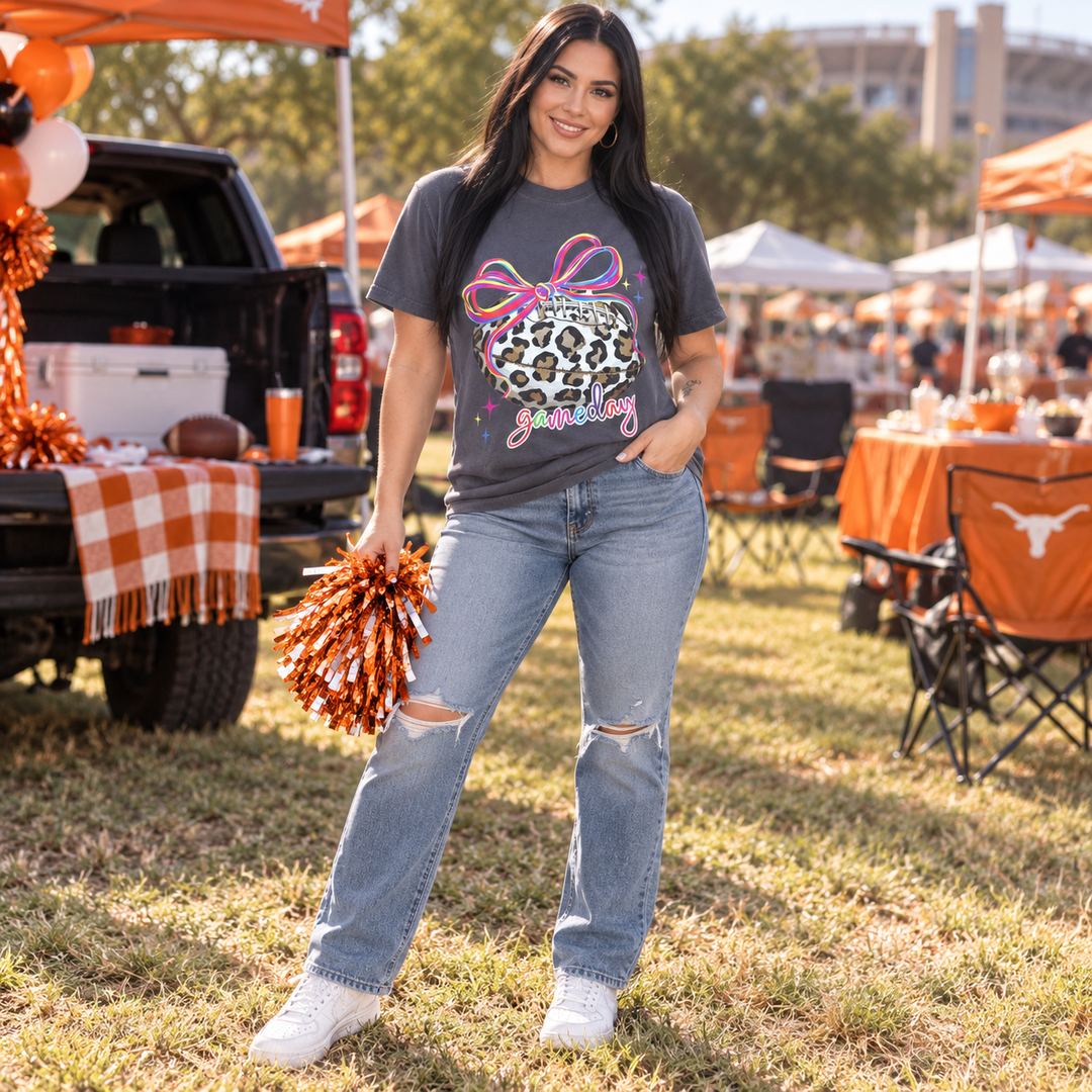 Woman wearing Neon Leopard Football Graphite Game Day tee at a fall tailgate