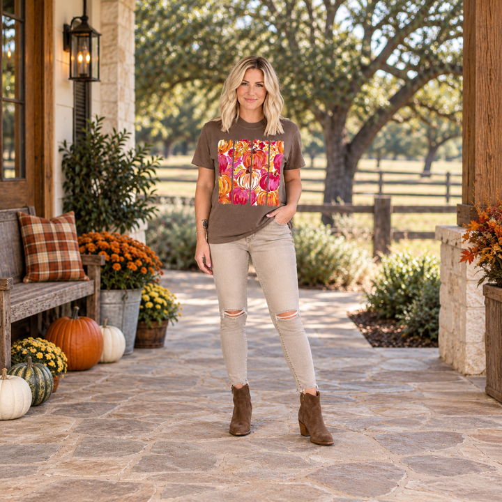 Blonde woman wearing the Paint-Stroke Pumpkin fall graphic tee on a Central Texas ranch porch