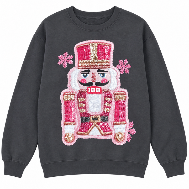 Charcoal pink faux-stitched nutcracker Christmas crewneck laid flat on pure white
