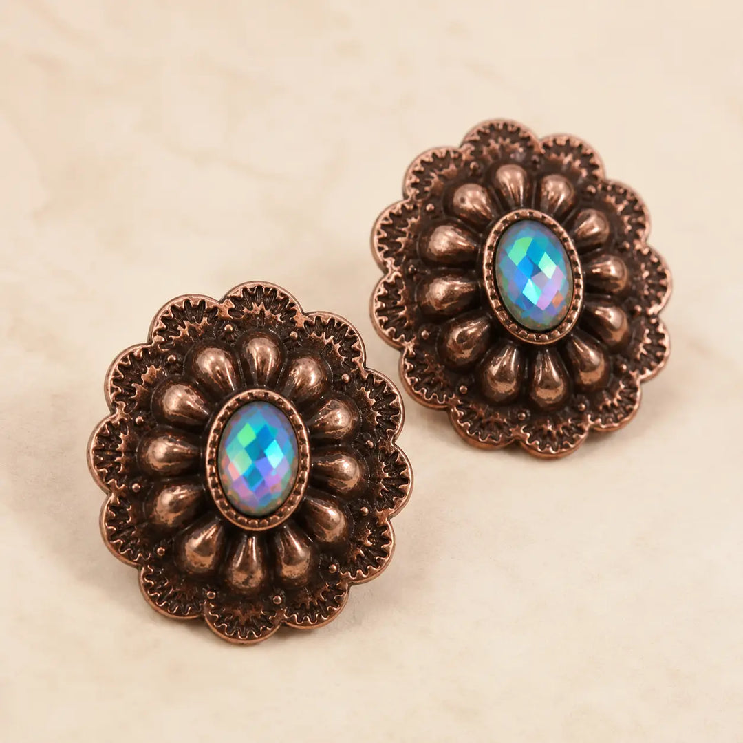 Close detail of copper-tone concho stud earrings with iridescent center stones