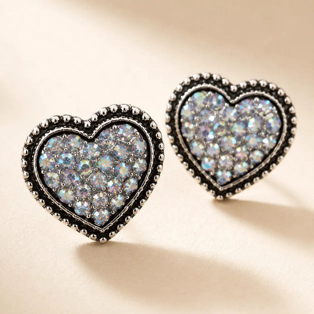 Close detail of silver-tone heart stud earrings filled with iridescent rhinestones