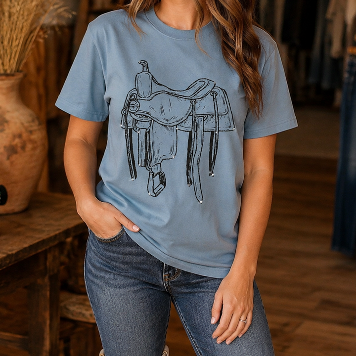 Woman wearing the dusty blue rhinestone saddle Western graphic tee