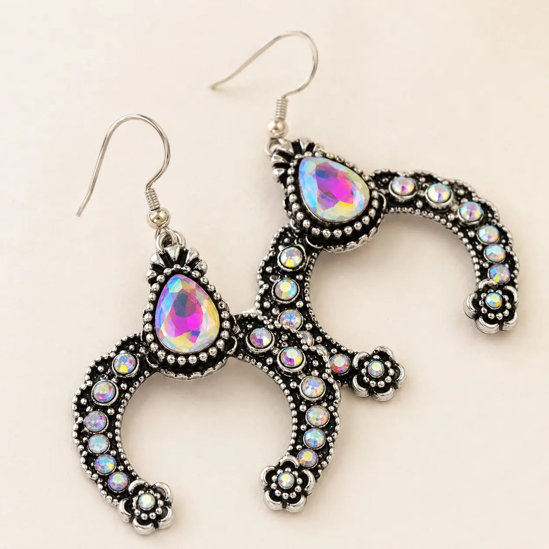 Close detail of silver-tone squash blossom earrings with iridescent rhinestones