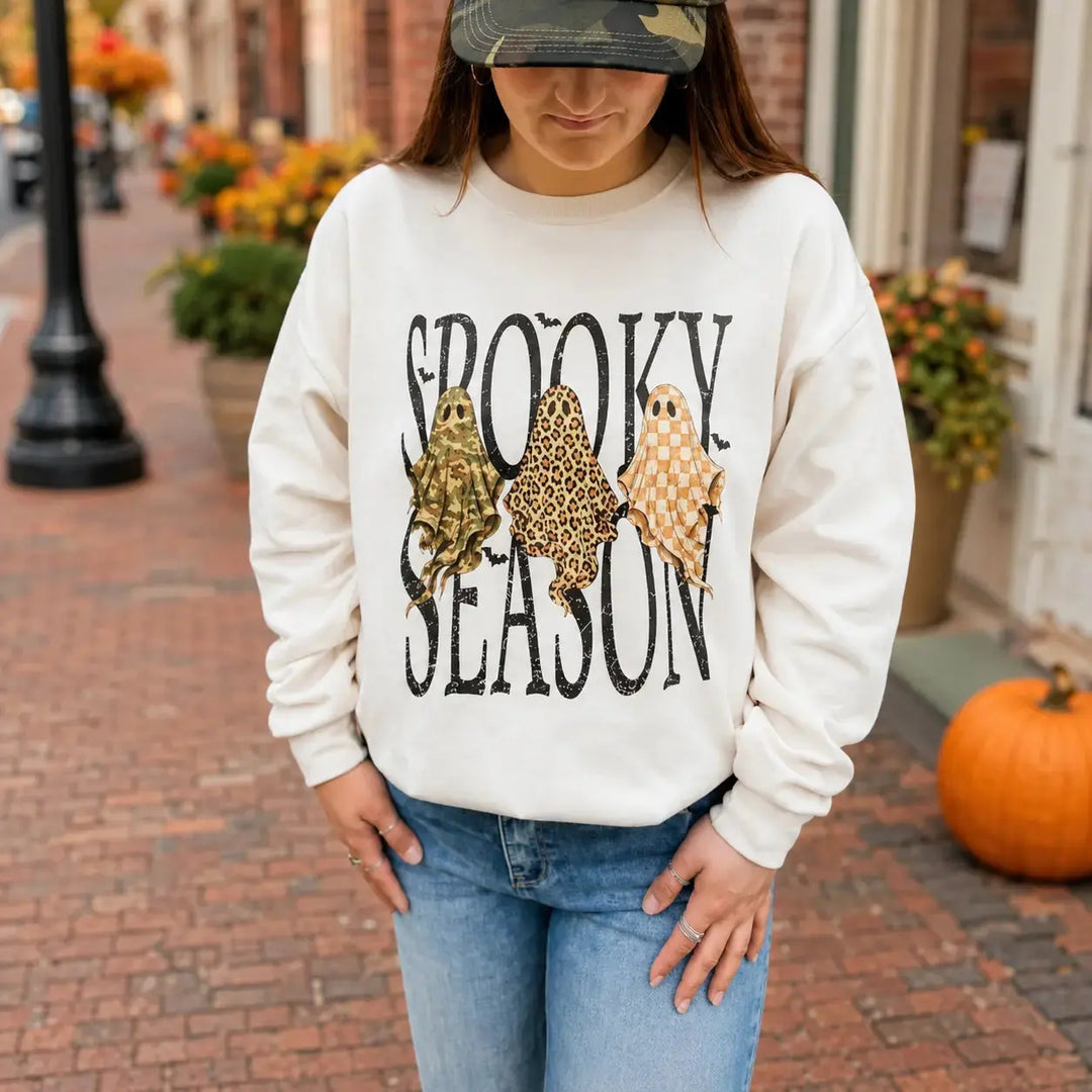Woman wearing the Spooky Season trio ghost Off White crewneck on an autumn street