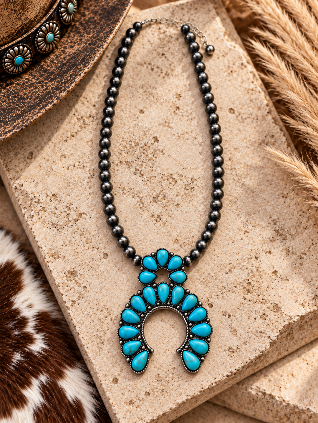 Close styled view of Turquoise Blossom Squash Necklace with silver-tone beads and turquoise horseshoe pendant