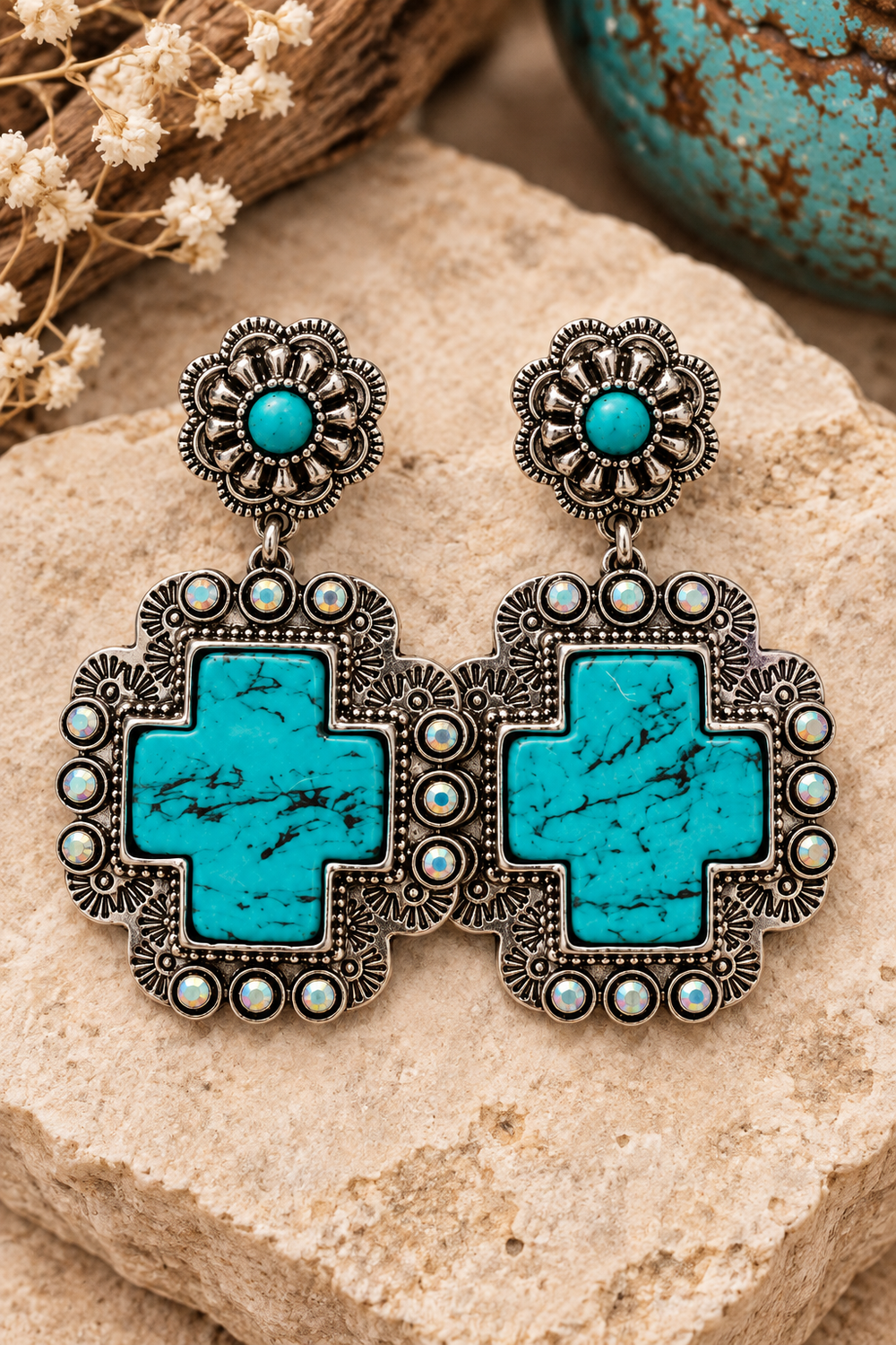 Close styled view of Turquoise Cross Statement Earrings with floral posts and silver-tone cross frames