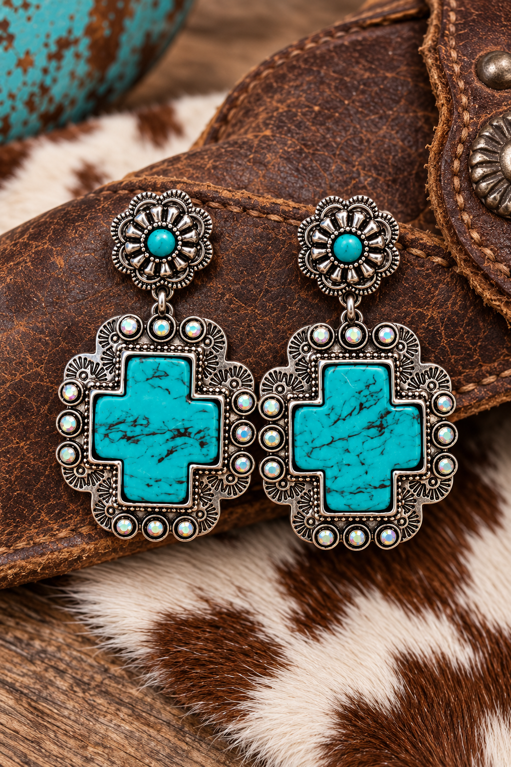 Turquoise Cross Statement Earrings styled on Western leather and cowhide