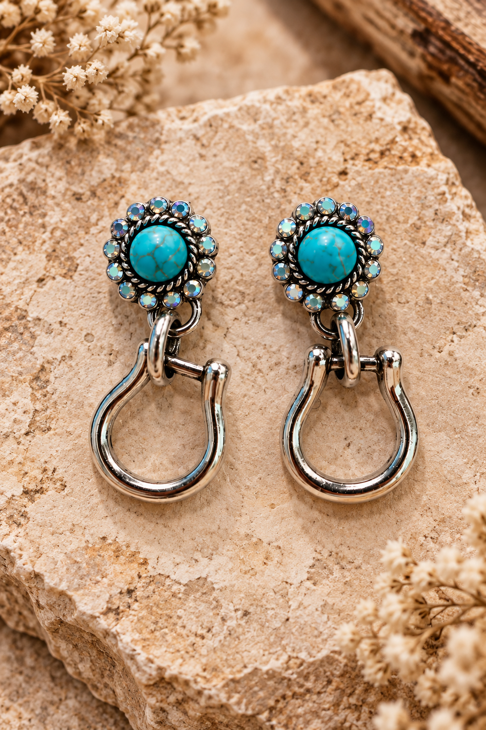 Close styled view of Turquoise Stirrup Earrings with turquoise floral posts and silver-tone stirrup drops