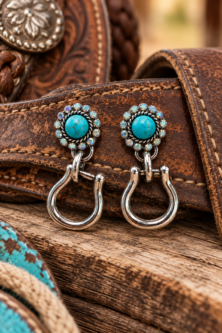 Turquoise Stirrup Earrings styled against weathered Western leather