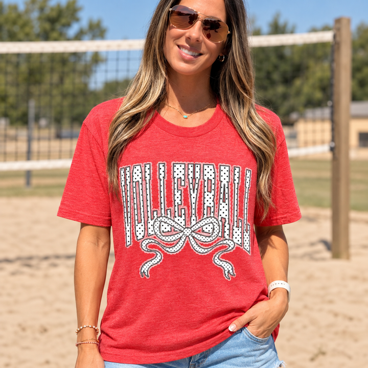 Volleyball polka dot bow graphic tee close model view at a small-town volleyball court