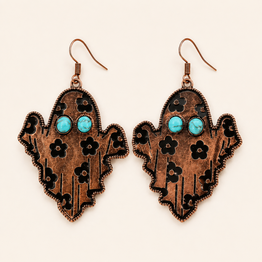 Copper-tone Western ghost dangle earrings with turquoise-colored eyes and black floral details, clean product view