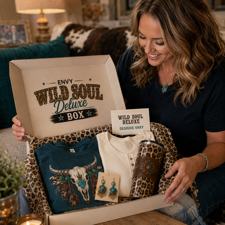 Woman opening an Envy Wild Soul Deluxe subscription box with representative items; designs vary
